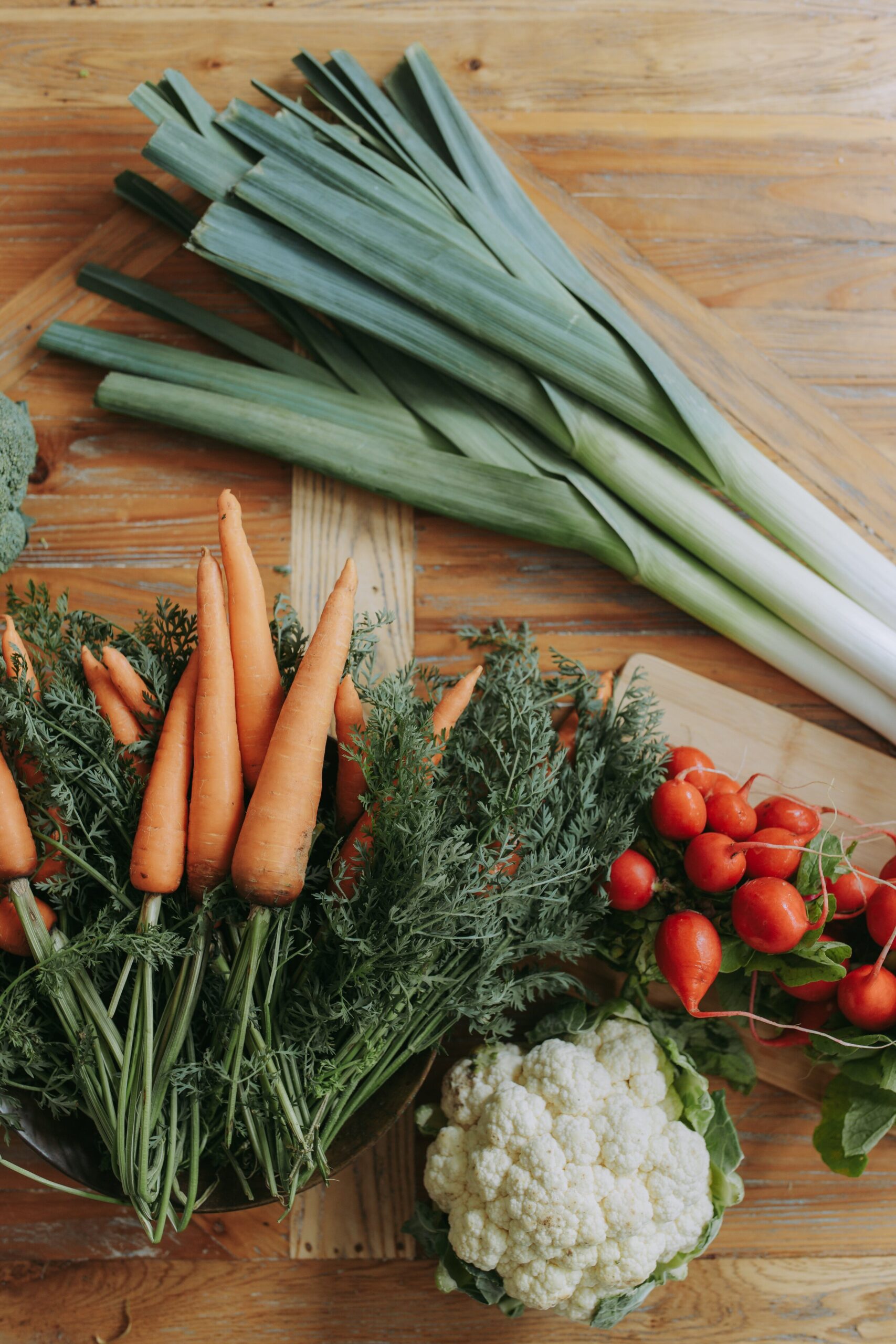 Raw vegetables displayed on a wood table