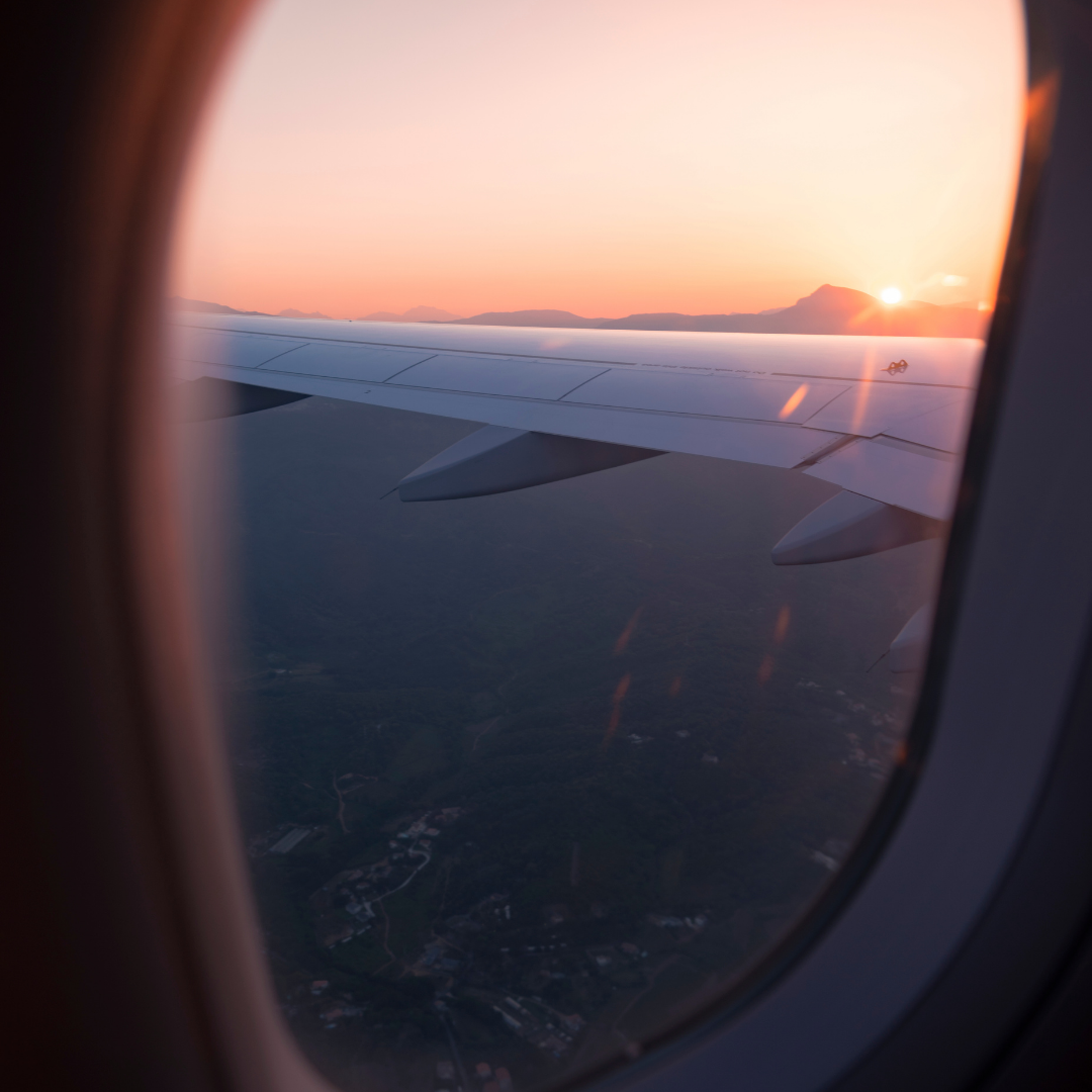 The wing of an aircraft viewed as seen through the window of a passenger