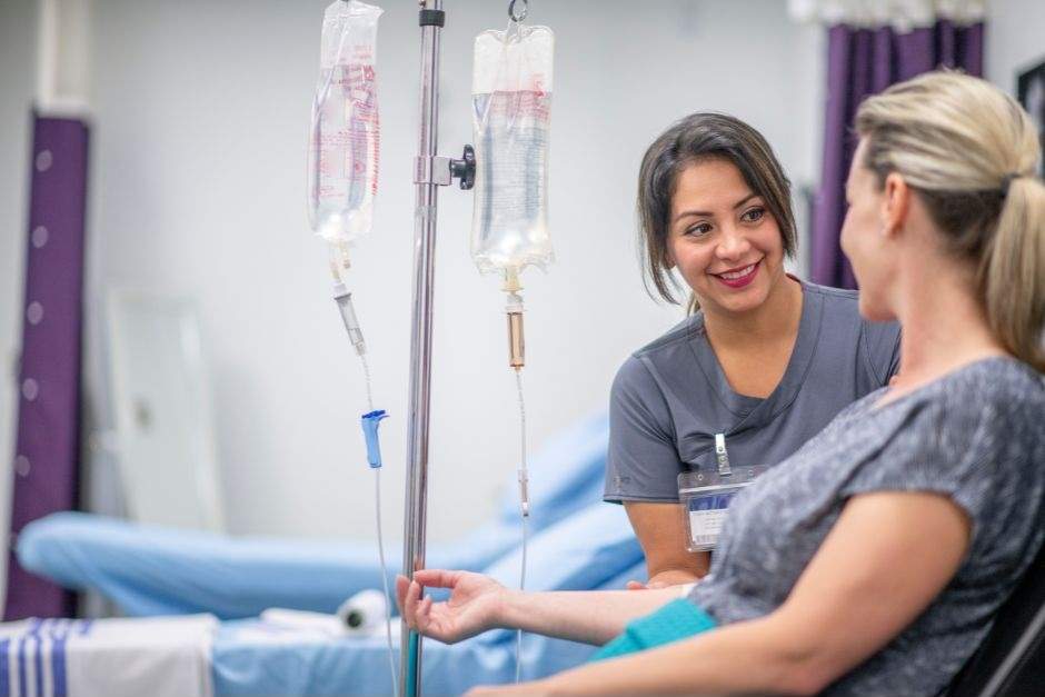 A woman administrating an IV to another woman